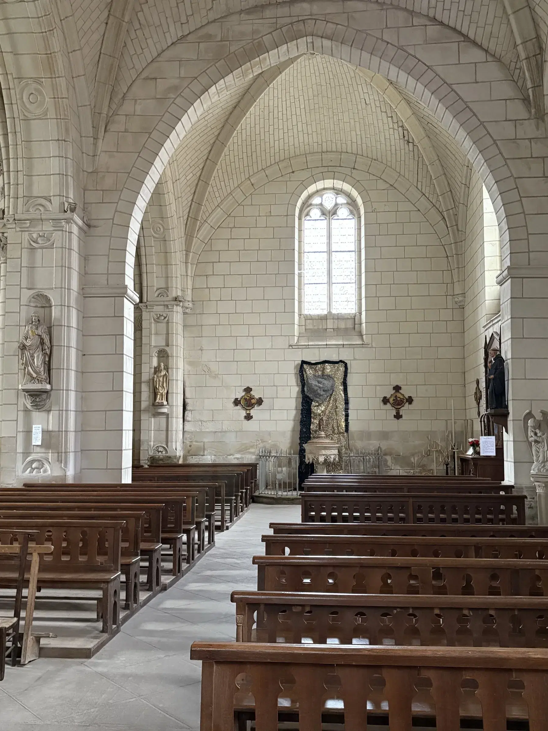 Wide view down the nave of the church of Saint-Épain toward Moffat Takadiwa’s installation.