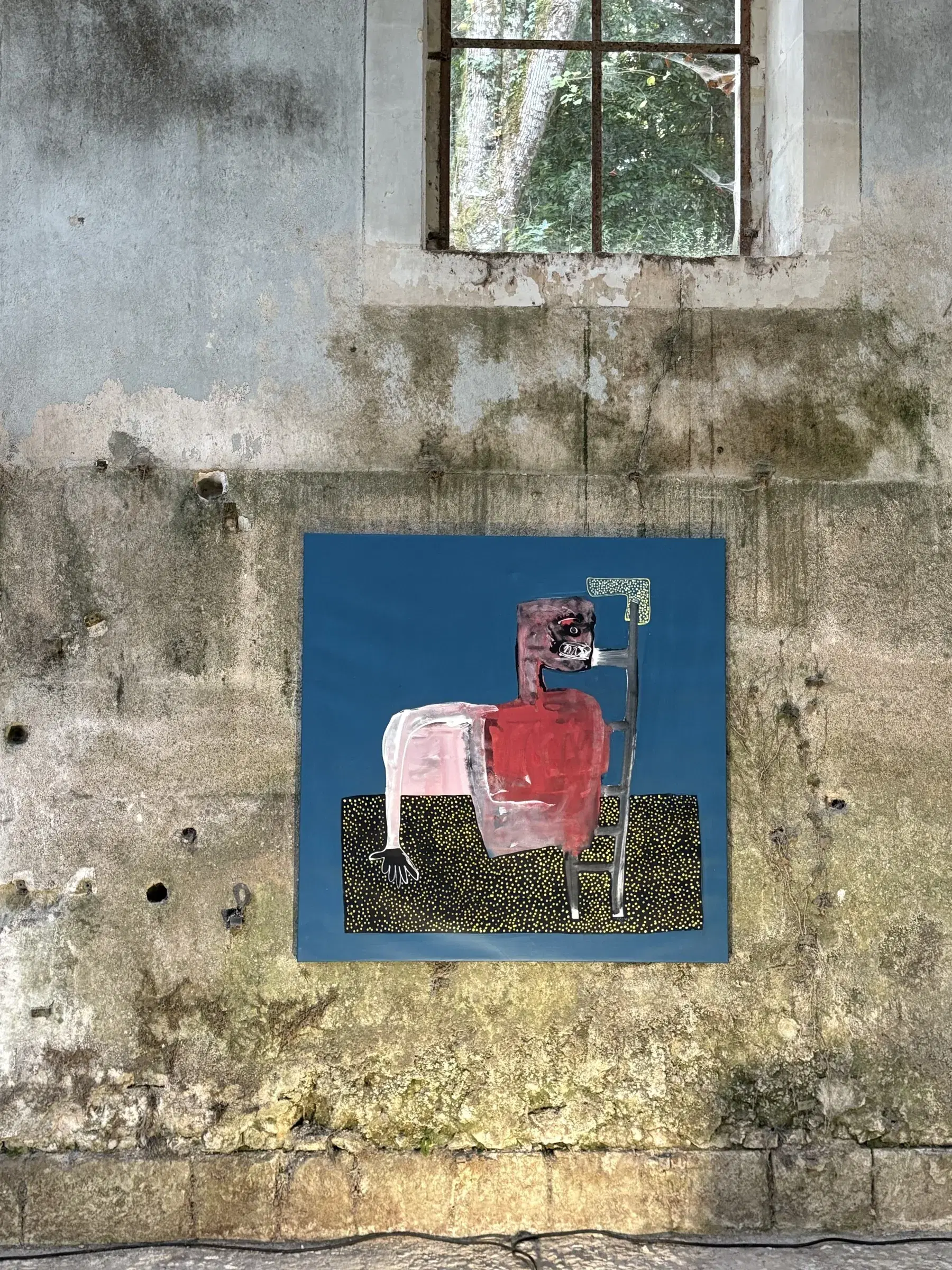 Blue mixed-media composition with a seated pink figure displayed in the exhibition.