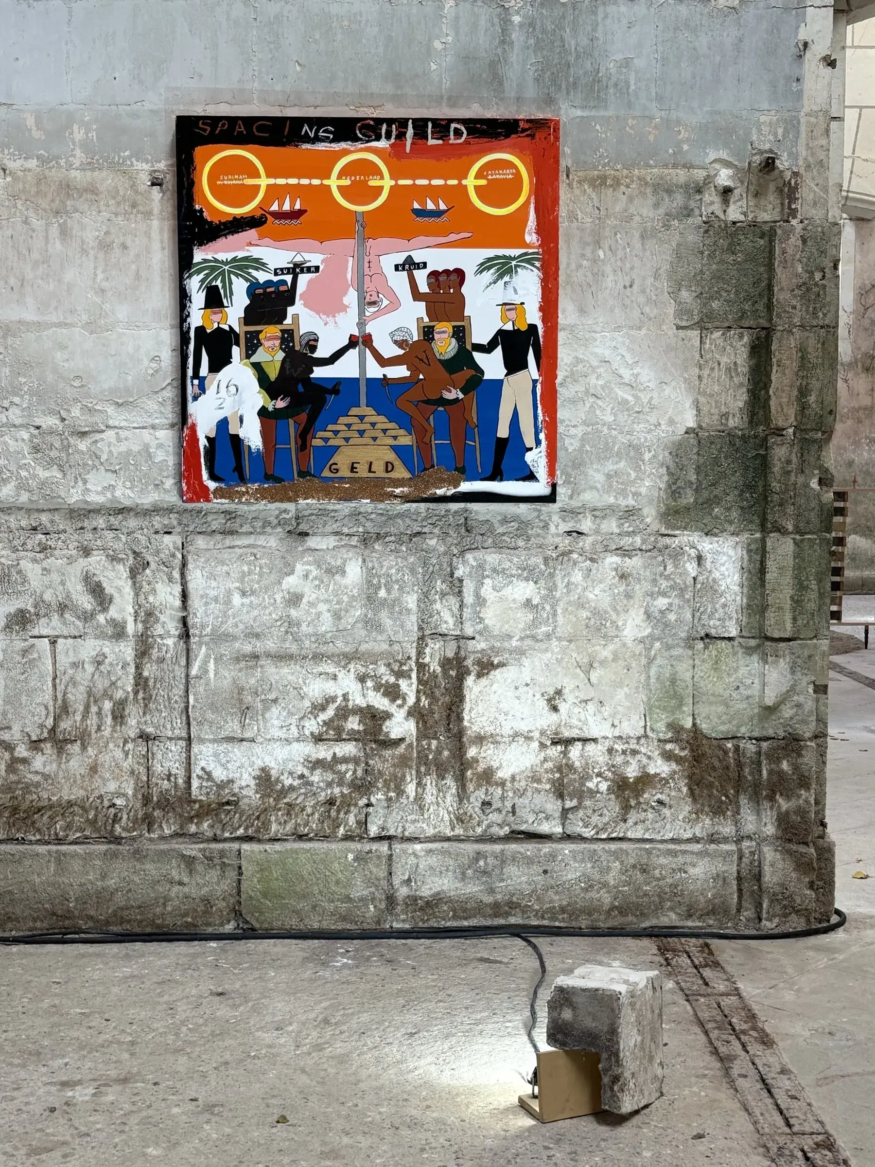 Colorful figurative painting displayed on a monumental stone wall within the exhibition route.