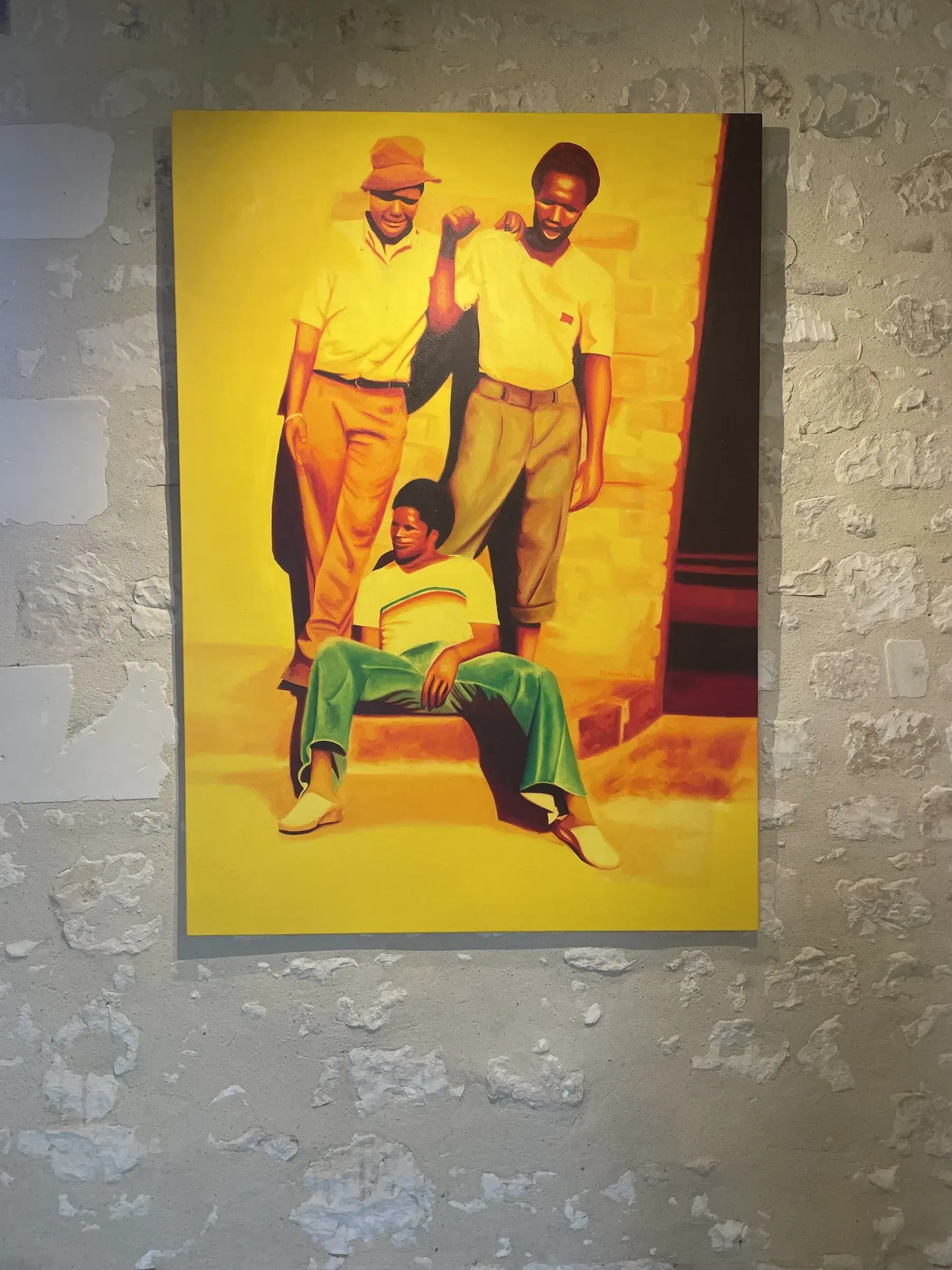 Mashudu Nevhutalu’s vivid yellow painting Bored at Home installed on a stone wall.