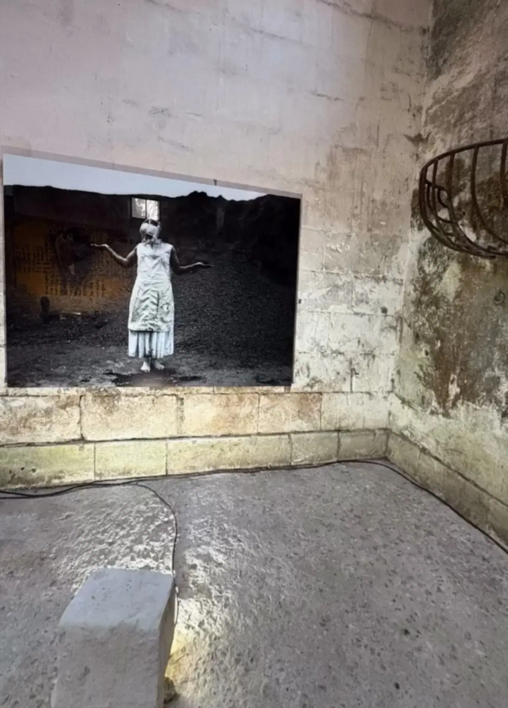 Mohau Modisakeng’s Endabeni installed on a weathered wall within the exhibition.