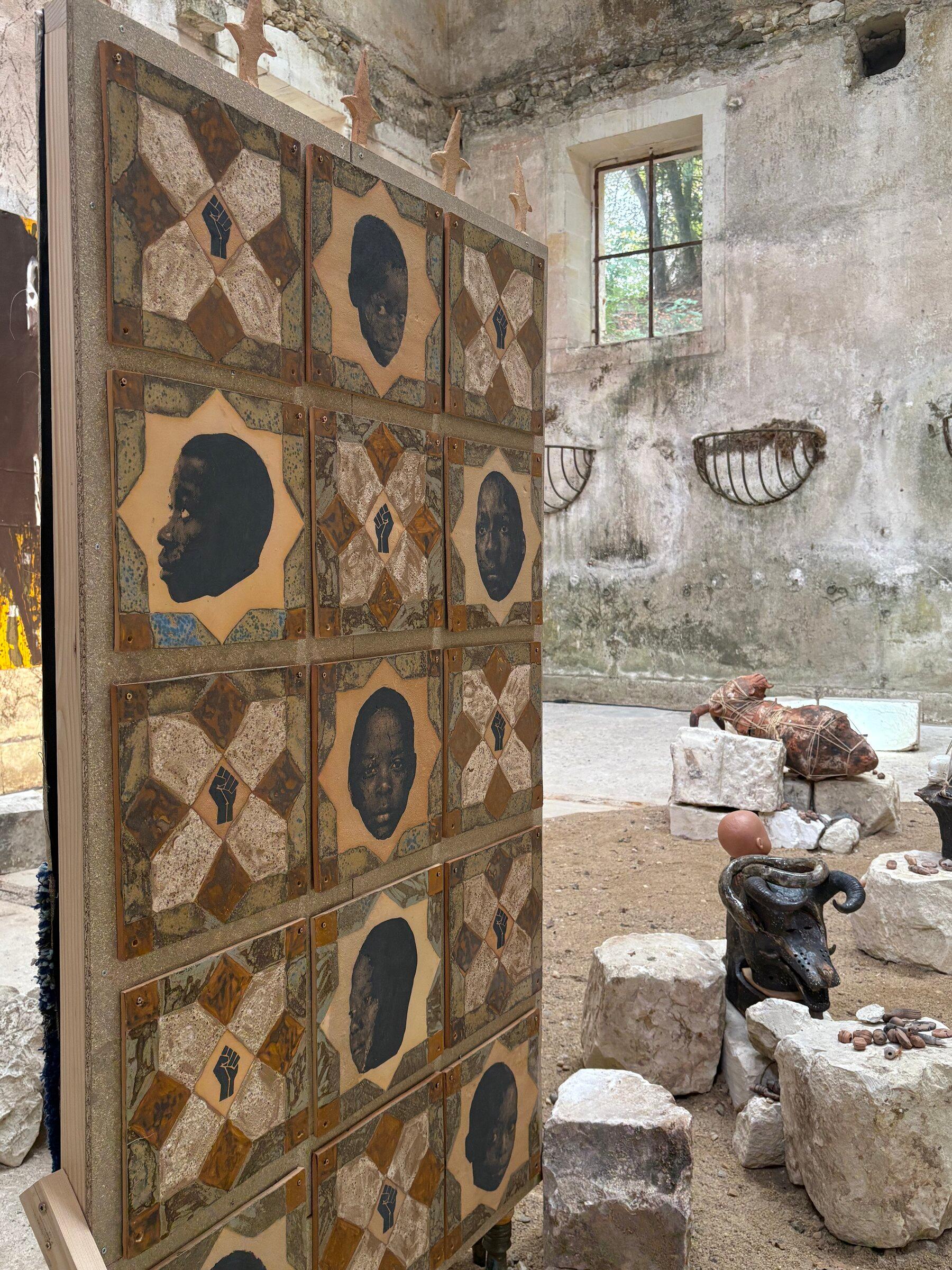 Large textile and sculptural works installed in a historic stone room at Château de Montgoger.