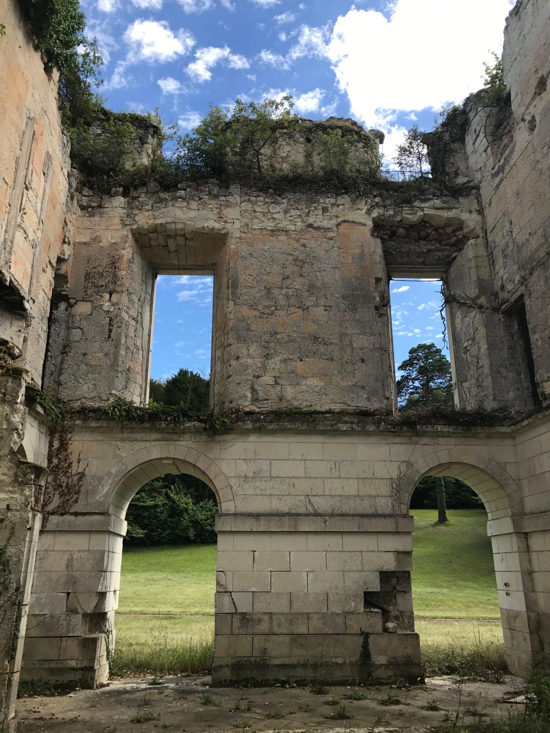 The historic ruins and architecture of Château de Montgoger seen from the landscape.