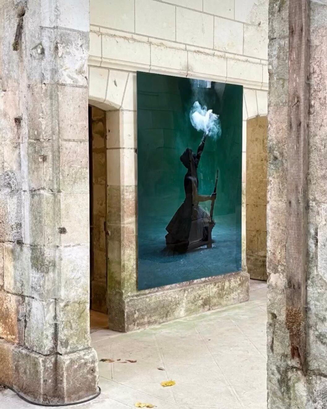 A material artwork installed in a rough historic interior wall.